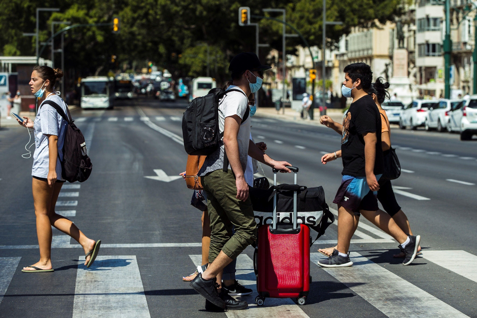 Un viajero con mascarilla cruza la Alameda principal este lunes.
