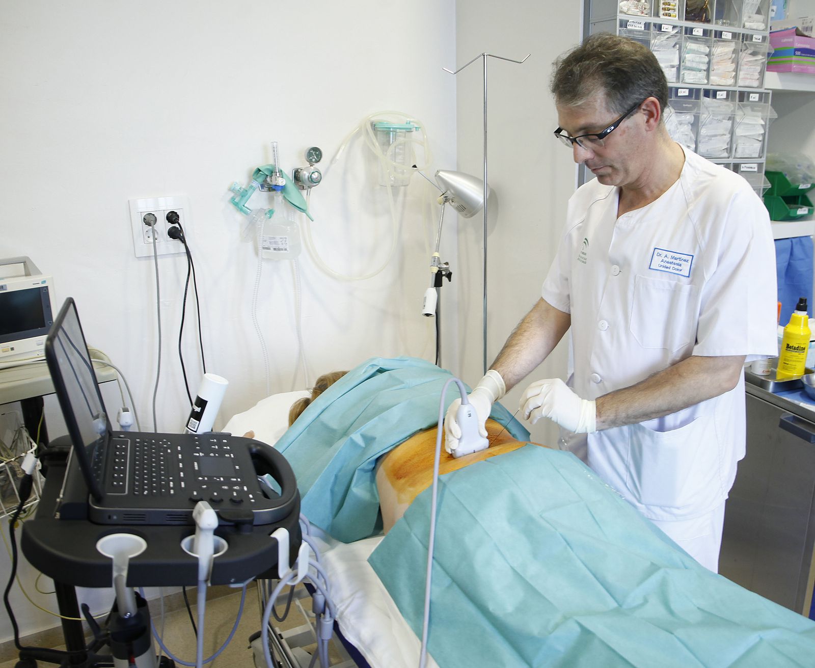 El doctor Ángel Martínez utliza la ecografía durante una punción para tratar dolores causados por hernias a una paciente en el Hospital El Tomillar.