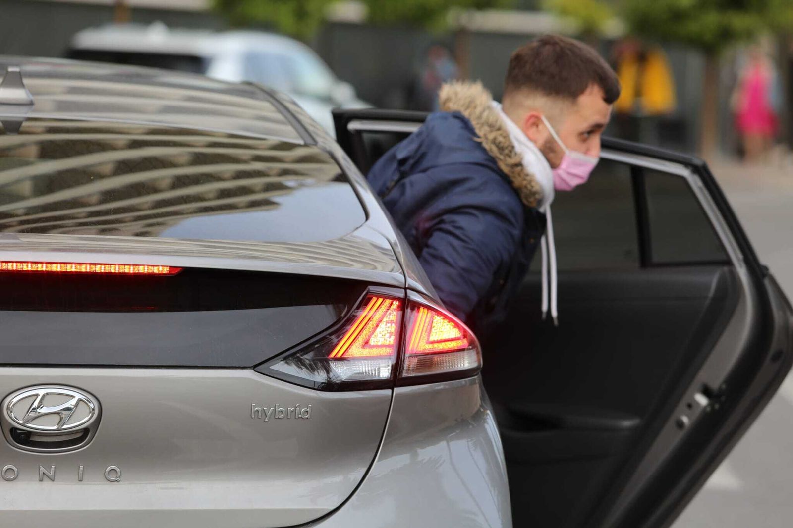 Un joven sale de un coche híbrido en Málaga.