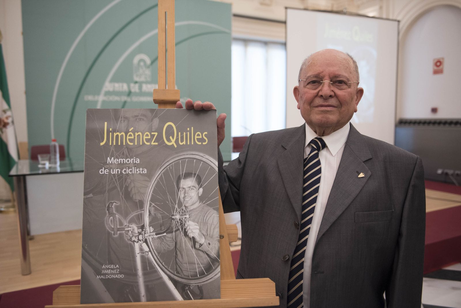 Antonio Jiménez Quiles, junto a una foto de la portada del libro.