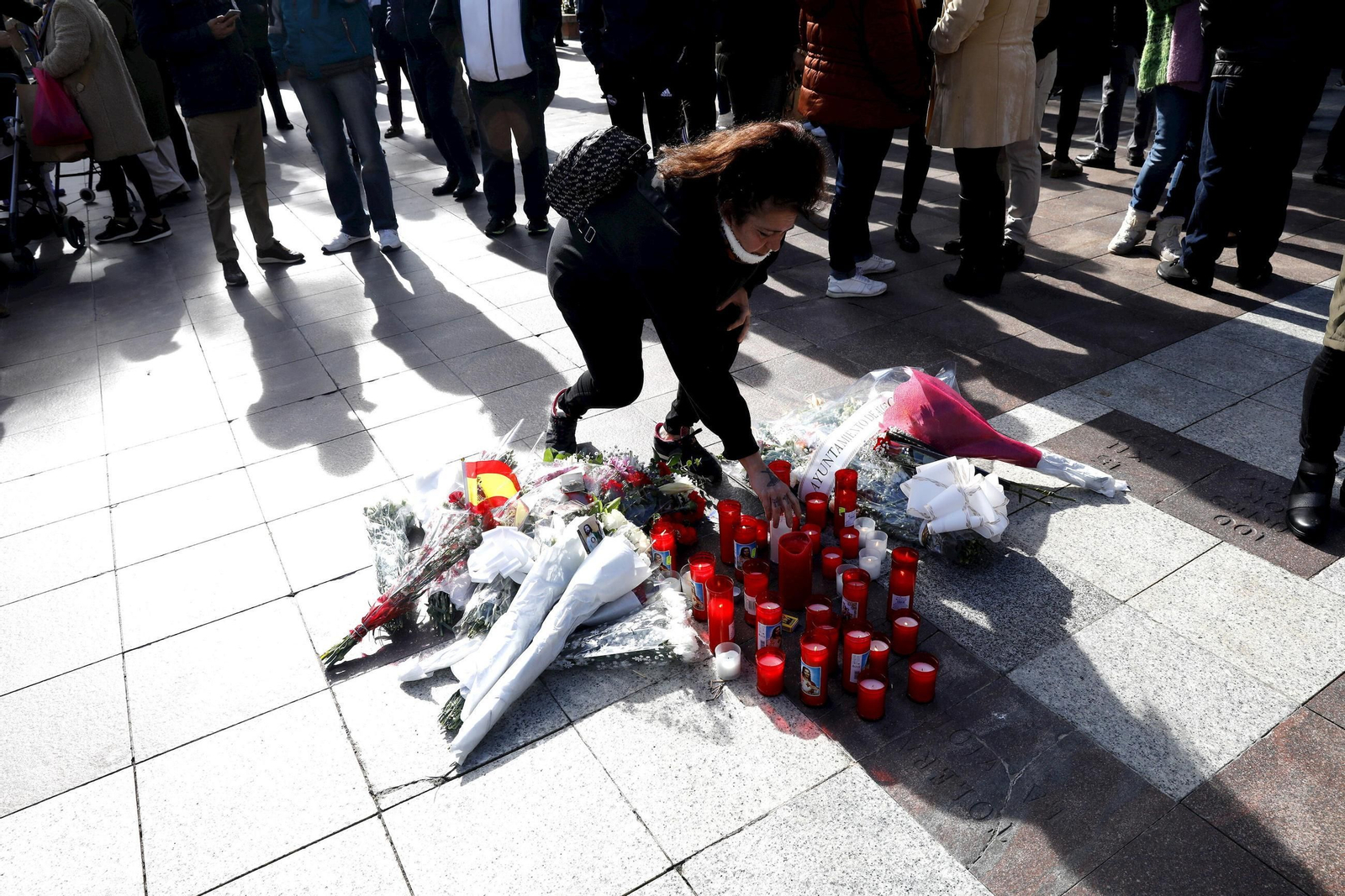 Una mujer deposita una vela en memoria de Diego Valencia al día siguiente del atentado.