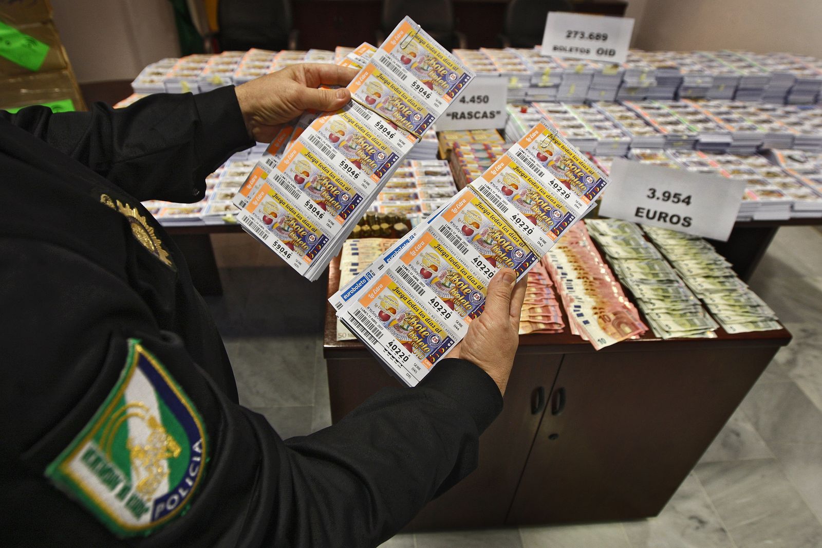 Un agente de la Policía Autonómica muestra algunos de los boletos incautados de la OID.