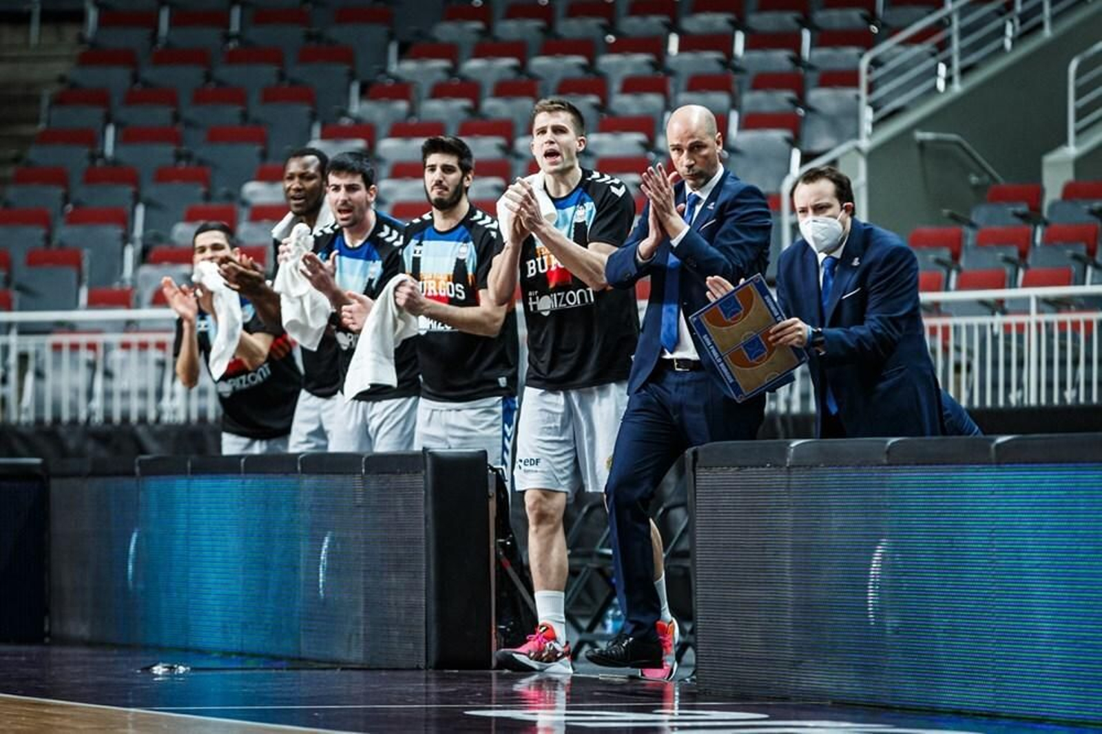 Joan Peñarroya y varios jugadores aplauden en el banquillo en Riga.