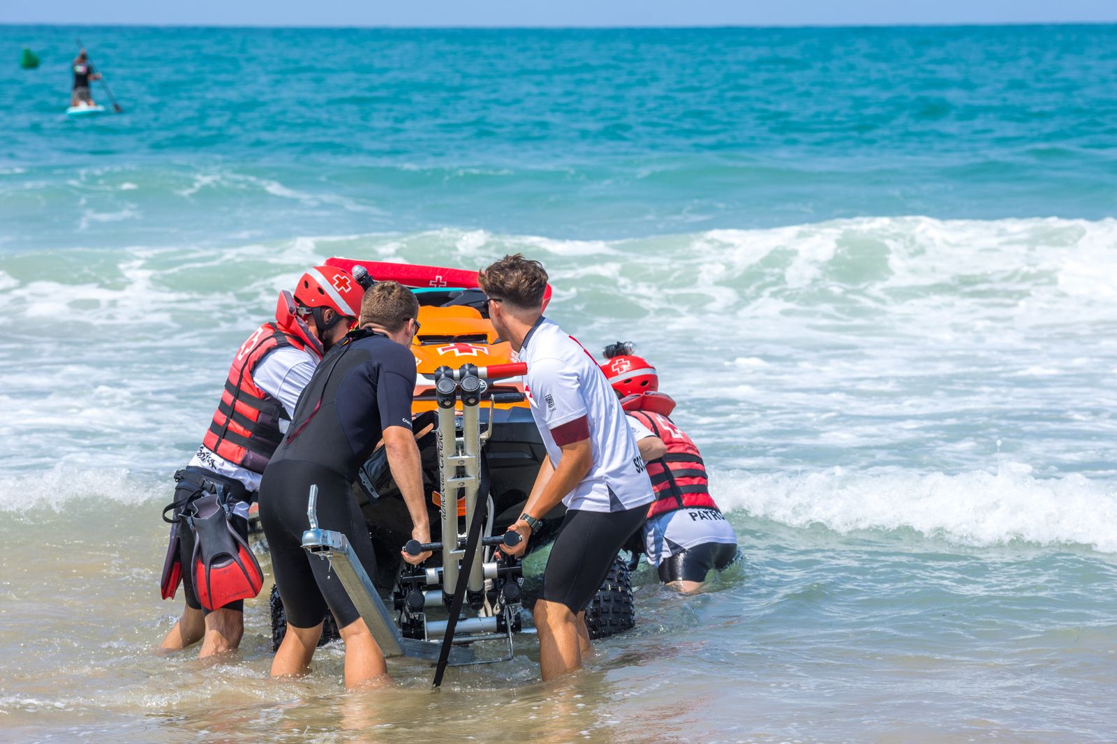 Personal del servicio de salvamento empuja una de las embarcaciones en el agua.