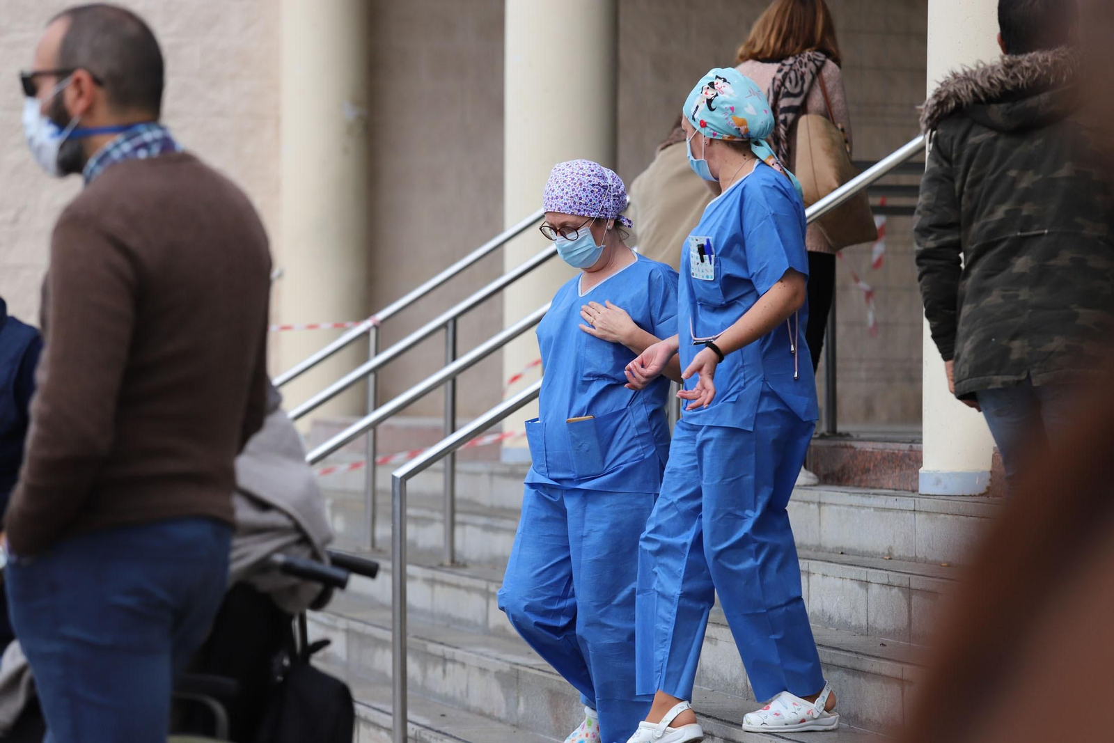 Dos sanitarias bajan las escaleras de la entrada al Hospital Juan Ramón Jiménez.