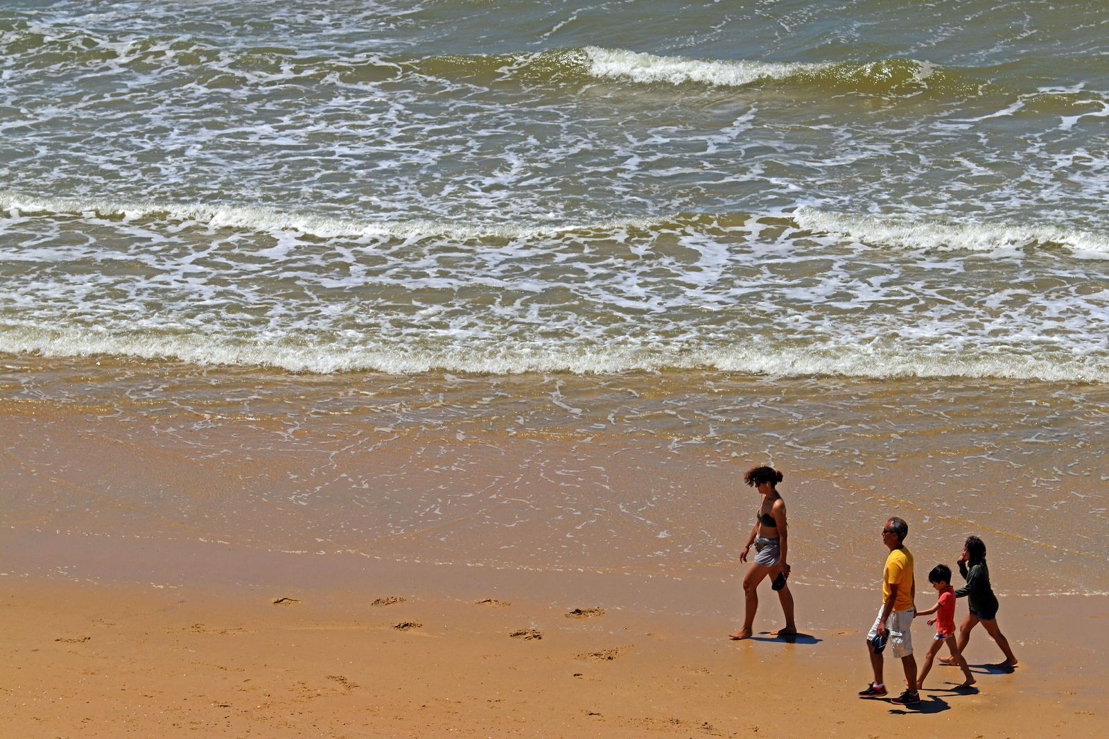 Una familia pasea por la playa de Matalascañas.
