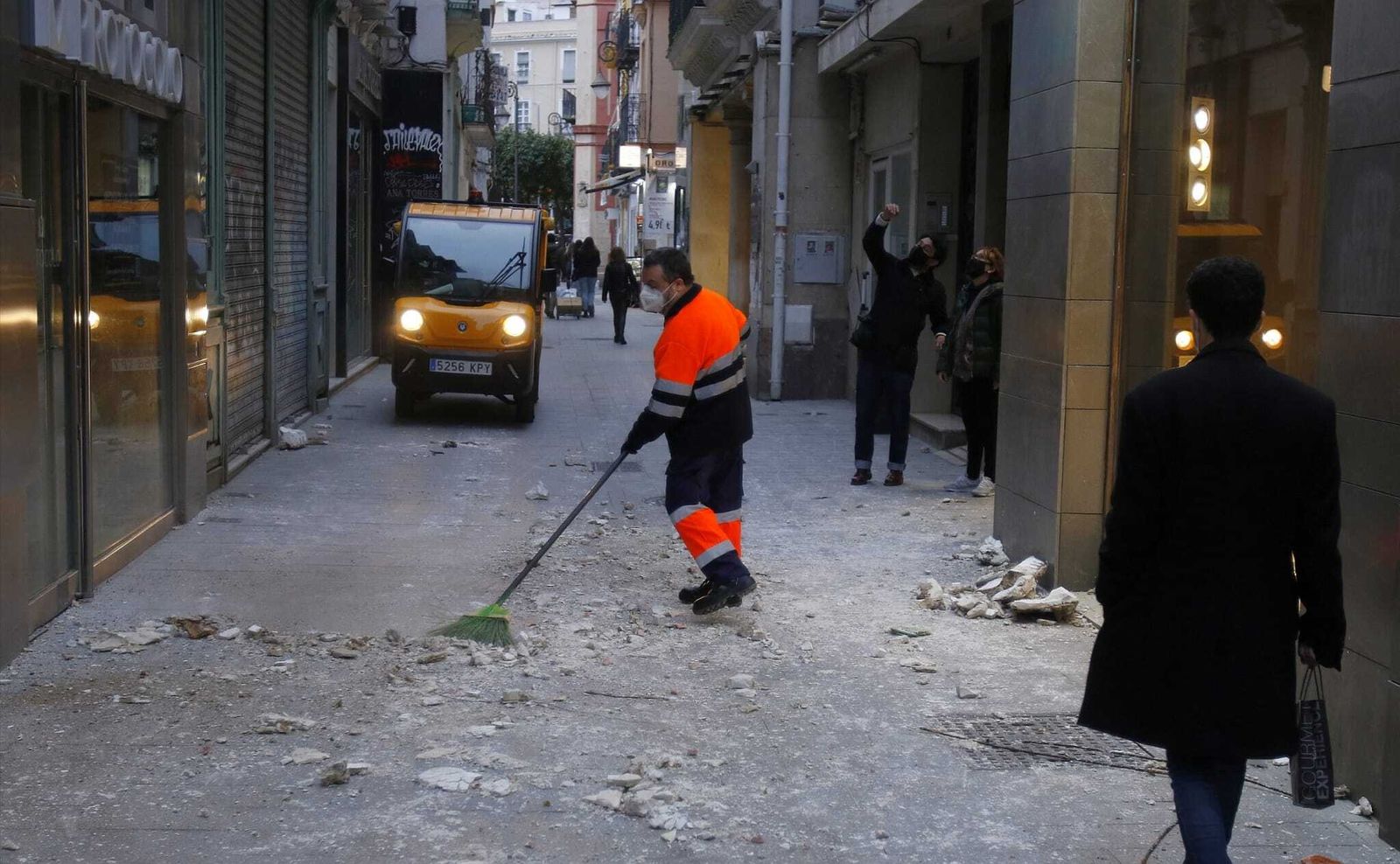 Un trabajador de Lipasam limpia los restos de la cornisa desprendida en la calle Cuna.
