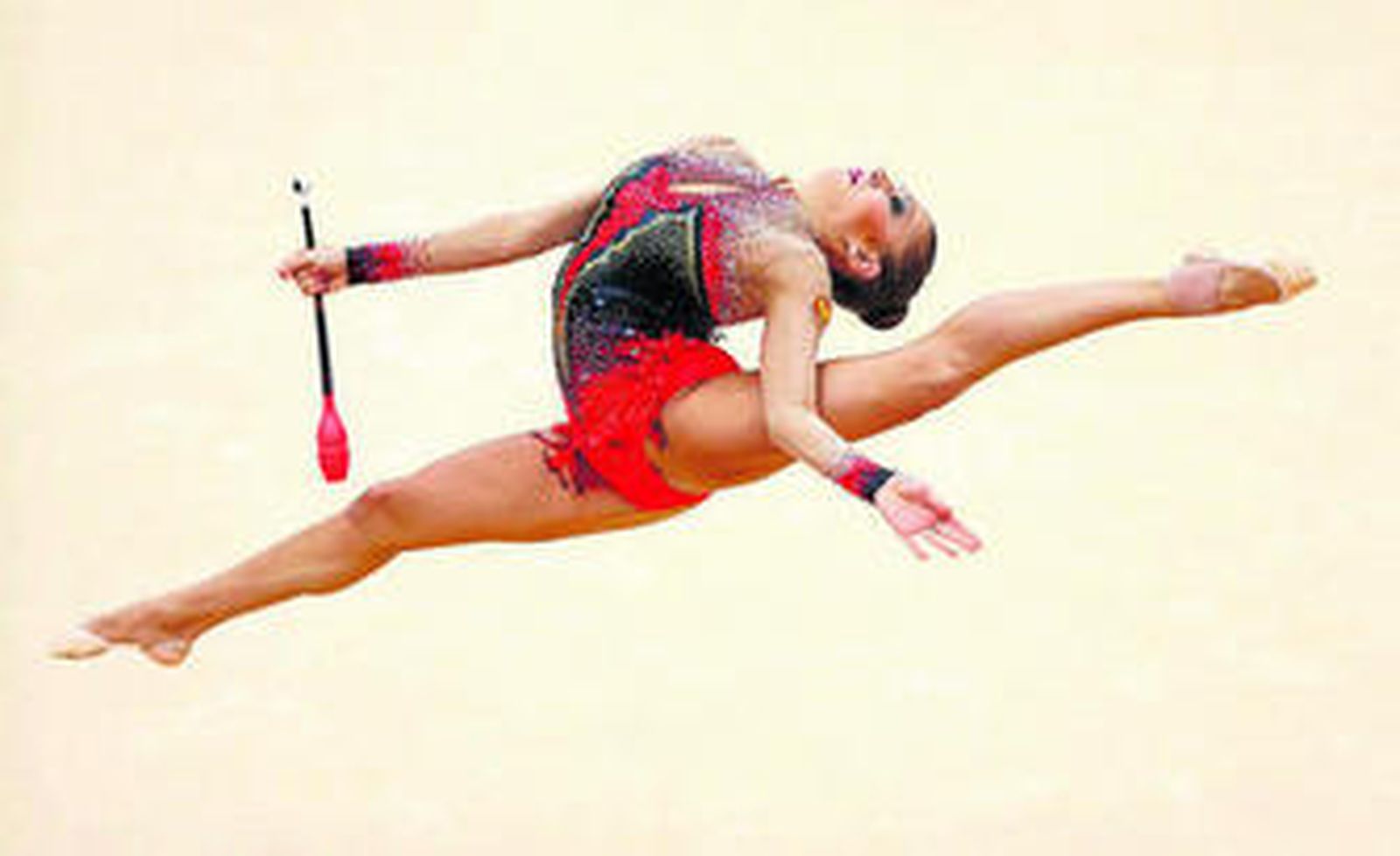 Kanaeva se estira en un salto durante su ejercicio con las mazas.
