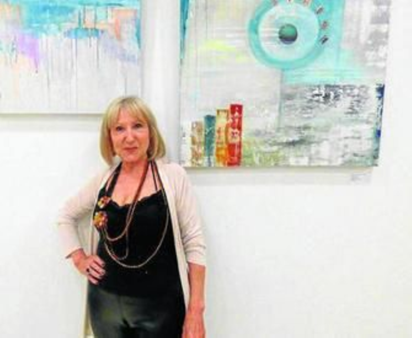 Victoria Melero posa ante sus obras en la sala del Ayuntamiento de Gelves.