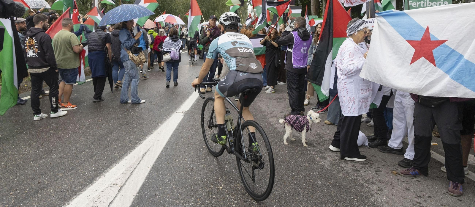 Un ciclista pasa entre los manifestantes en la meta que estaba prevista.