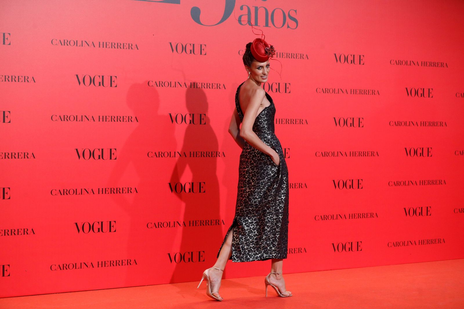 Nieves Álvarez, con vestido midi brocado en gris plomo de Carolina Herrera y tocado rojo de Philip Treacy.