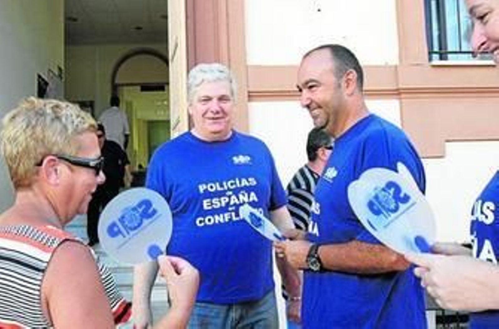 Los miembros del SUP reparten abanicos entre los usuarios que acuden a las dependencias de Fernández Ladreda.