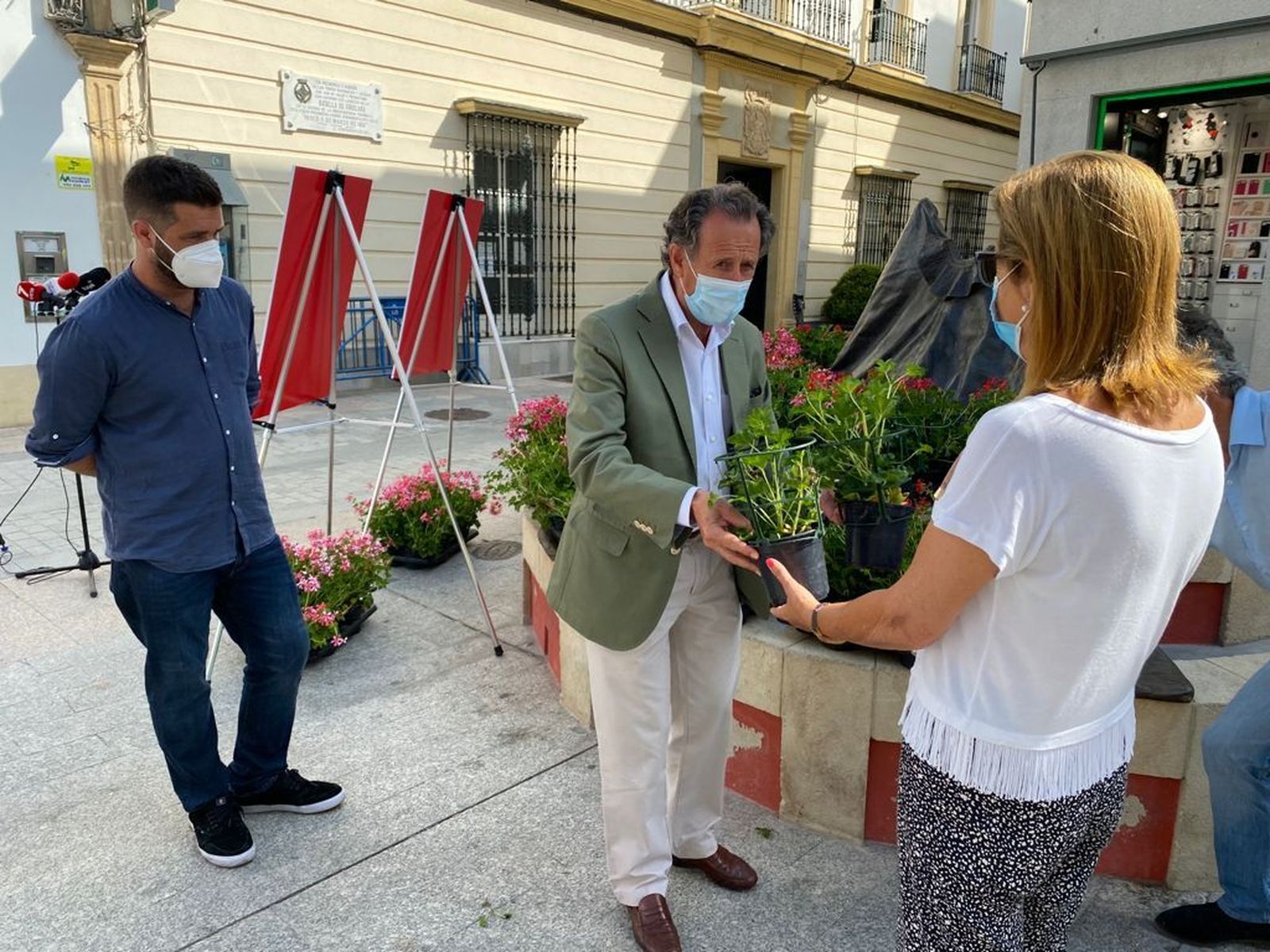 El alcalde, José María Román, hace entrega de macetas a la ciudadanía.