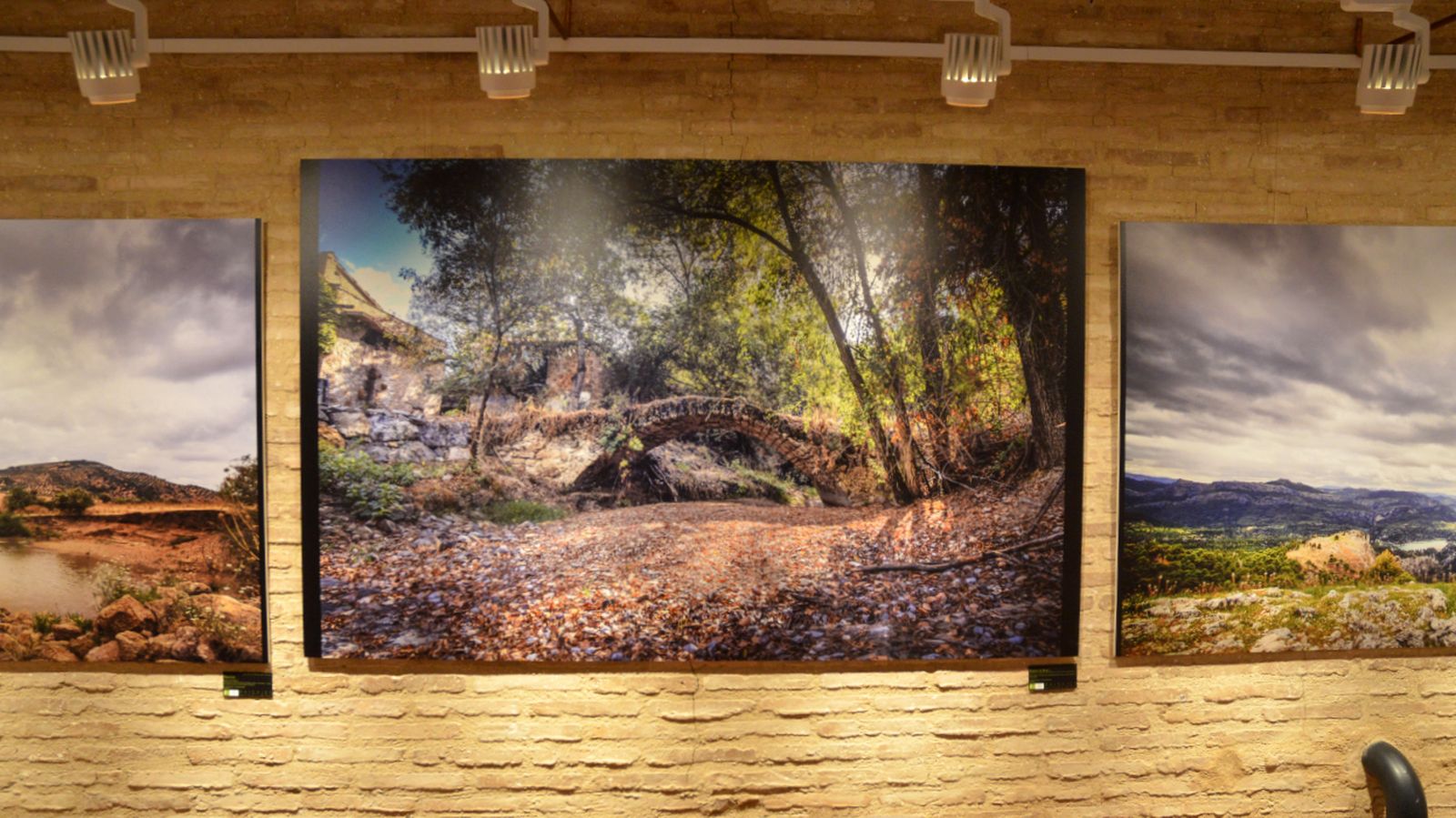 La imagen ganadora del III Premio de Fotografía sobre el Paisaje Giennense 2025, con el Puente de la Nubla sobre el río Cañamares como protagonista, expuesta en el Antiguo Hospital de San Juan de Dios de Jaén.