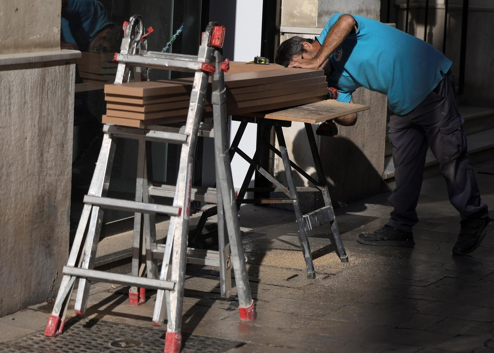 Un operario trabaja con listones de madera en Málaga.