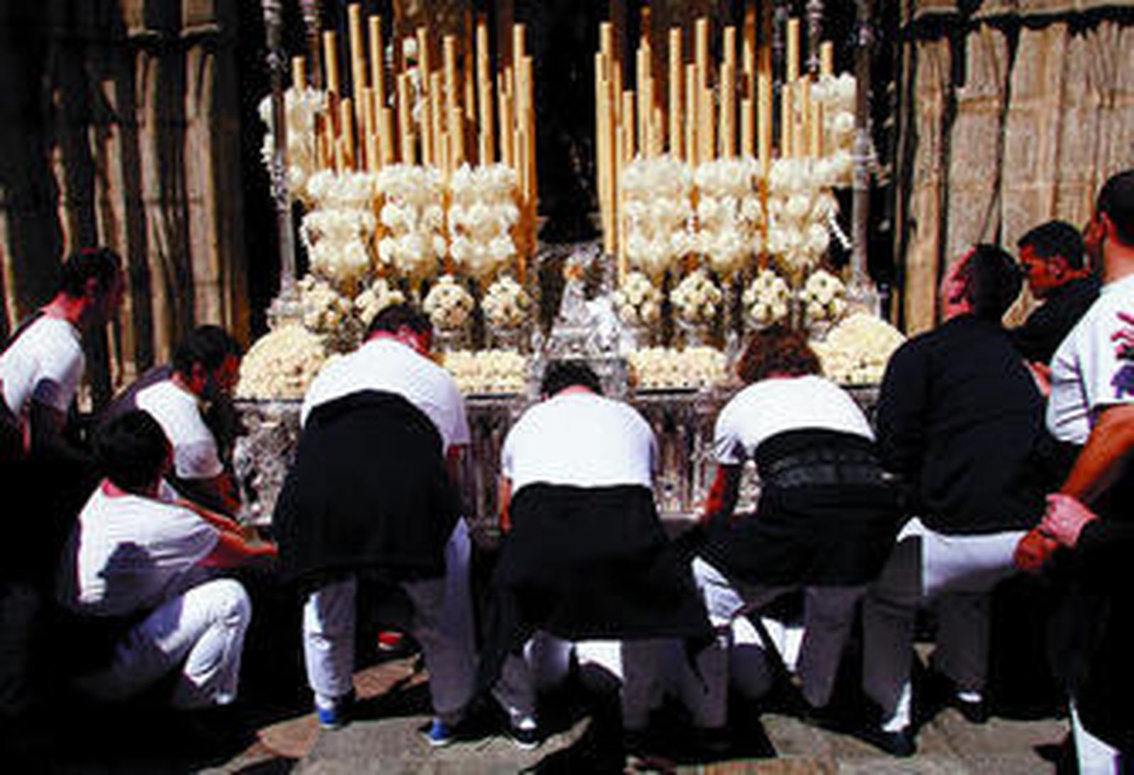 Los costaleros del palio de los Desamparados ayudan desde fuera a sus compañeros a superar la ojiva de San Esteban.