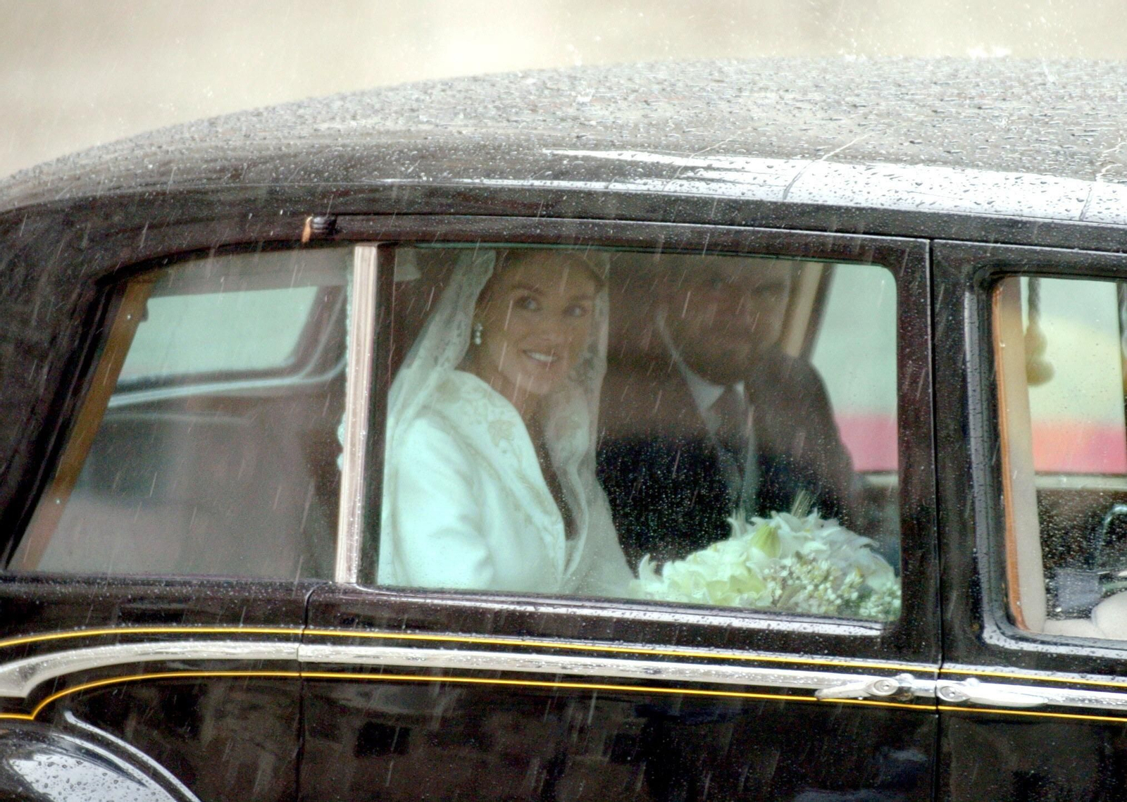 Doña Letizia y su padre,  Jesús Ortiz, padrino de la novia, a la llegada a la catedral madrileña entre la lluvia