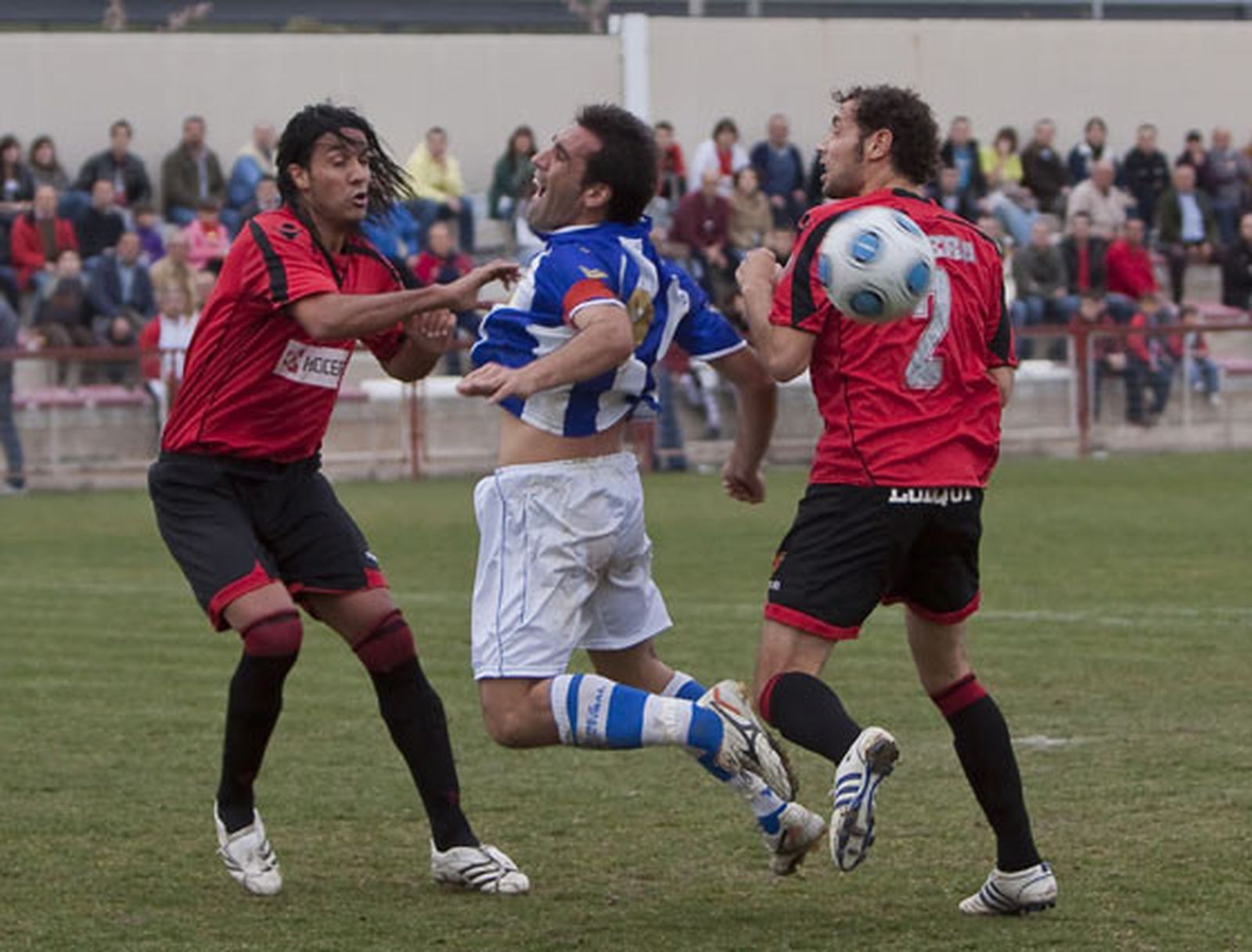 Dani Carrasco salta dentro del área entre dos defensas y pide penalti.

Foto: LOF