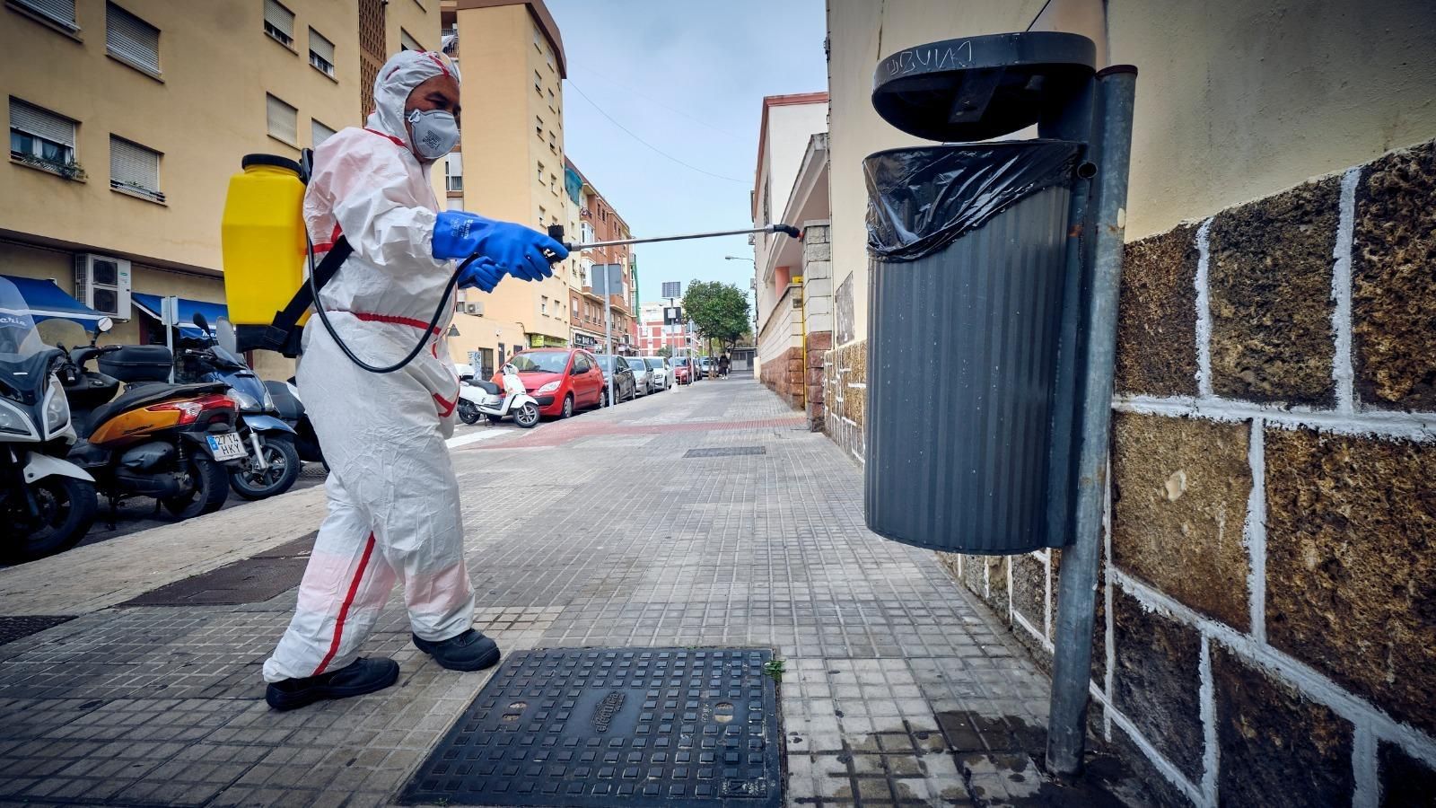 Trabajos de desinfección en una papelera, con la bolsa de plástico en su interior