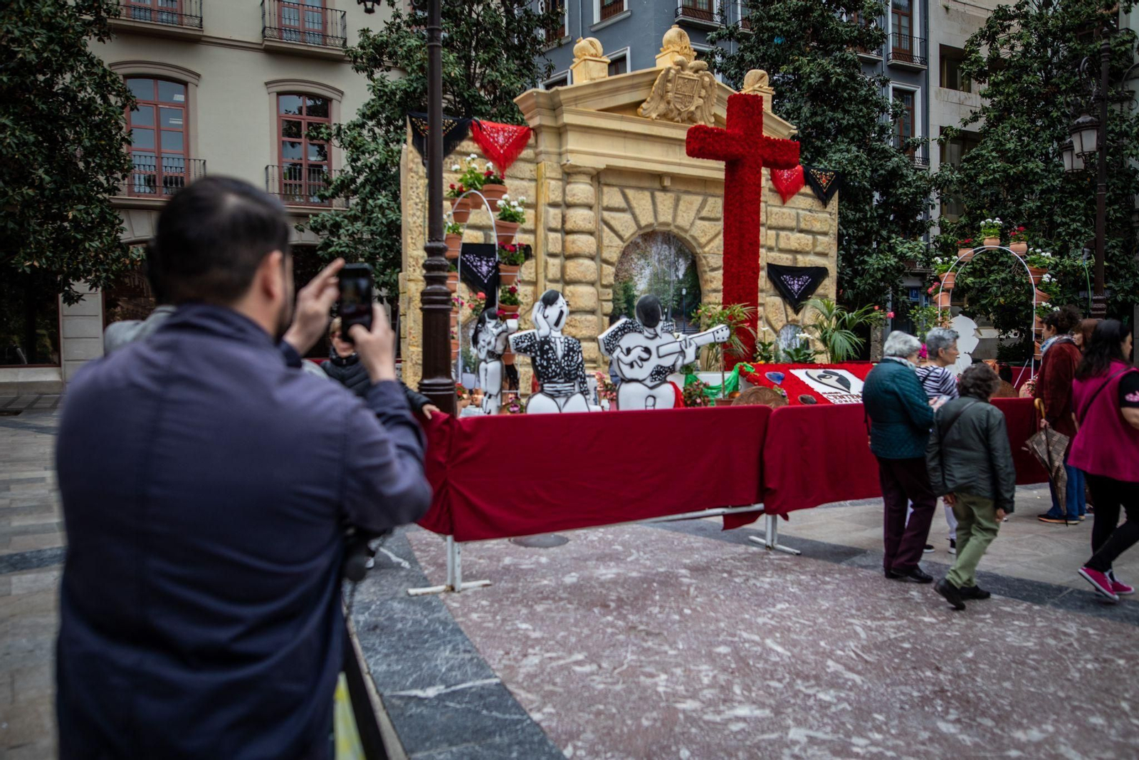 Una persona toma fotos de la cruz del Ayuntamiento de Granada