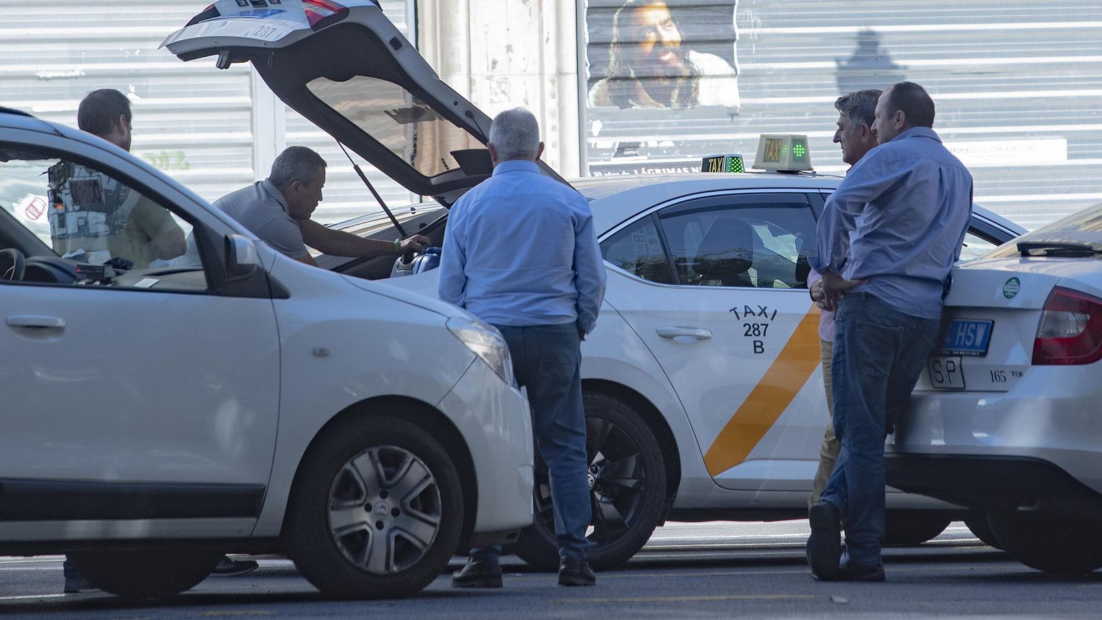 Varios conductores en una parada de taxi.