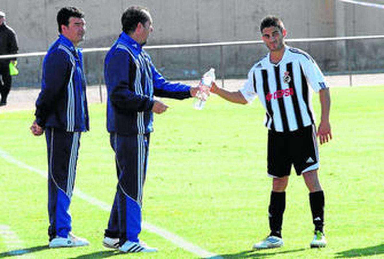 Escobar (izquierda), mientras Chichi le da una botella de agua a Francis.