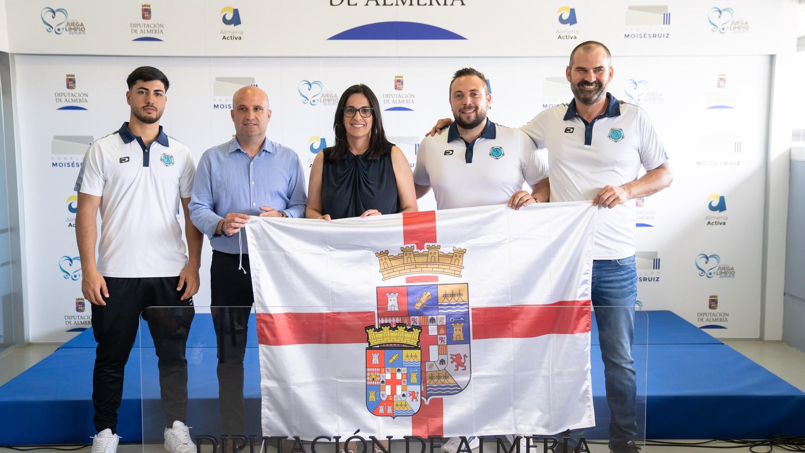 José Antonio García, Alejandra Carreño y el cuerpo técnico posan con la bandera de la provincia.