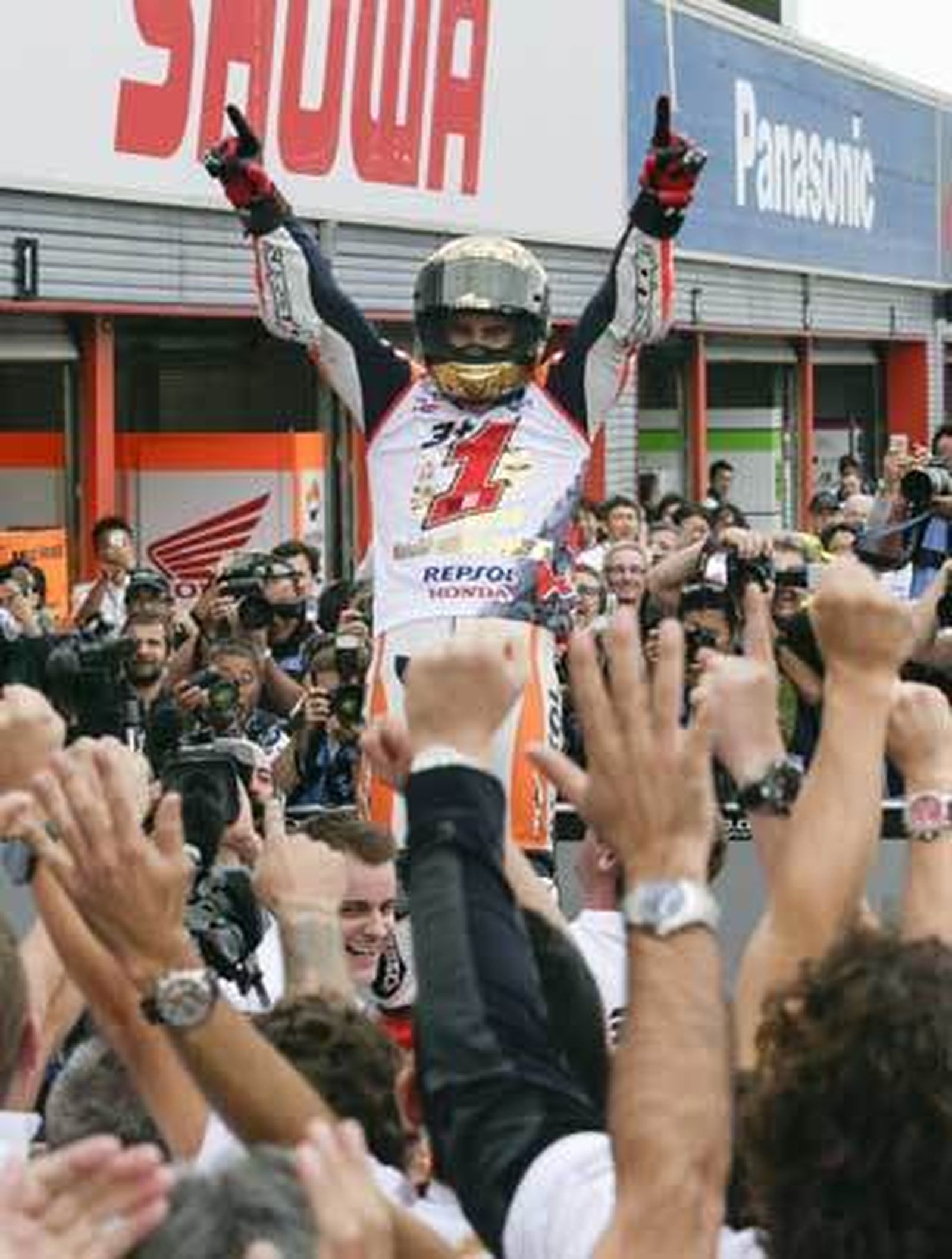 Marc Márquez, con una camiseta conmemorativa que le señala como el número uno del presente Mundial, a su llegada a boxes. /EFE
