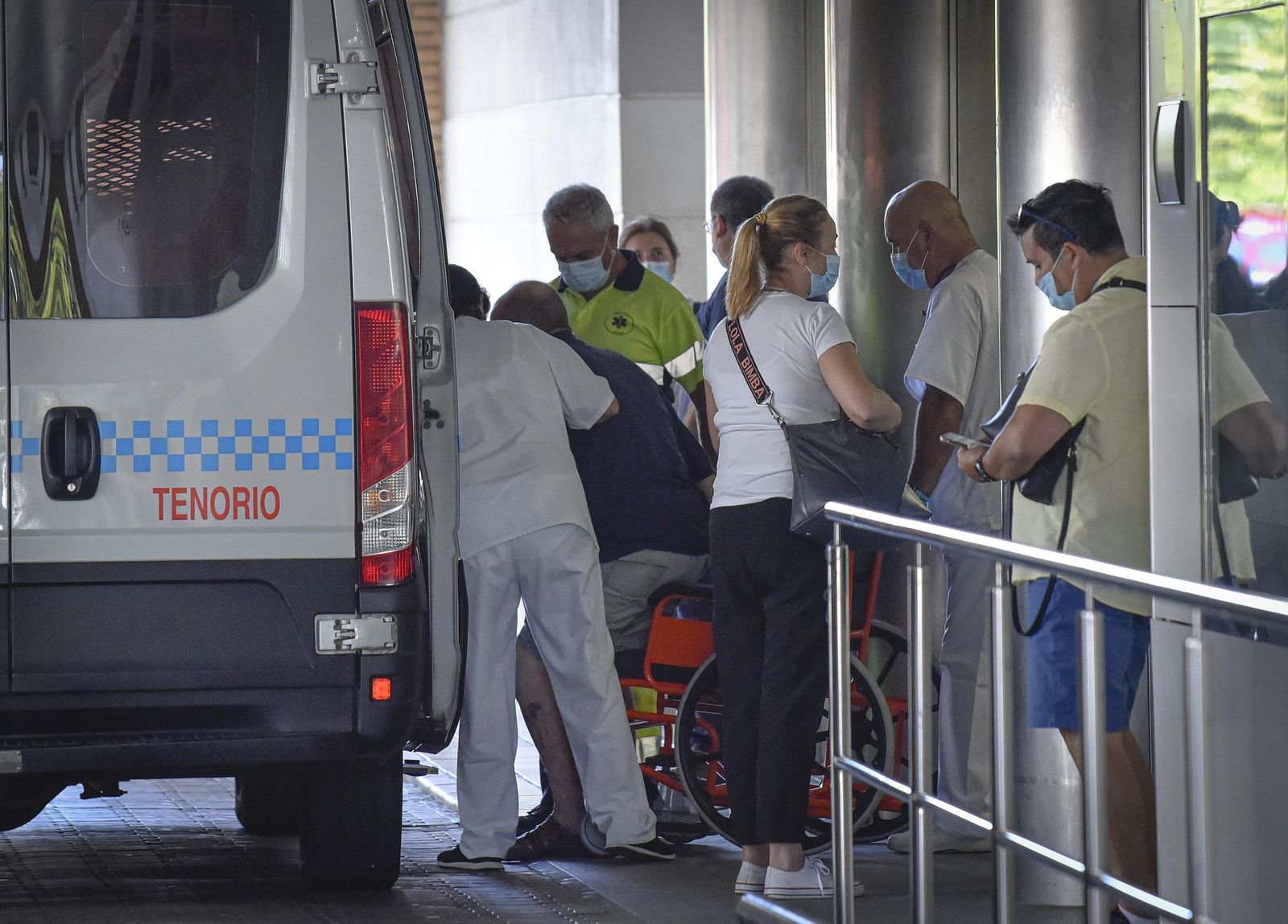 Un pacientes es ayudado a subir en una ambulancia entre un grupo de personas en las Urgencias del Macarena.