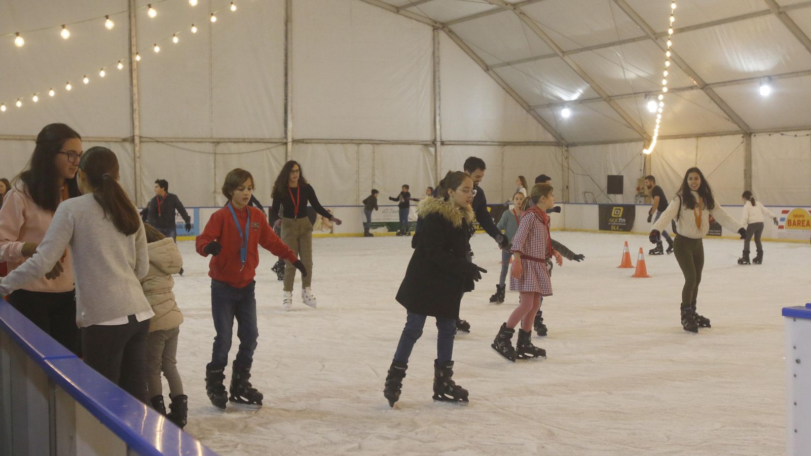 Un grupo de niños disfruta de la pista de hielo instalada en el Vial Norte.