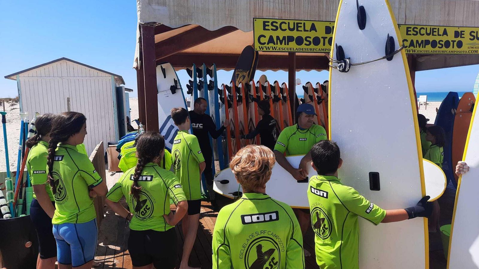 Un grupo de chicos atiende las explicaciones sobre surf en Camposoto.