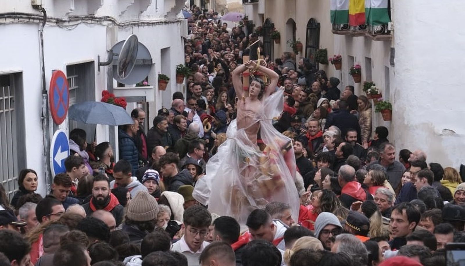 San Sebastián procesiona protegido de la lluvia.