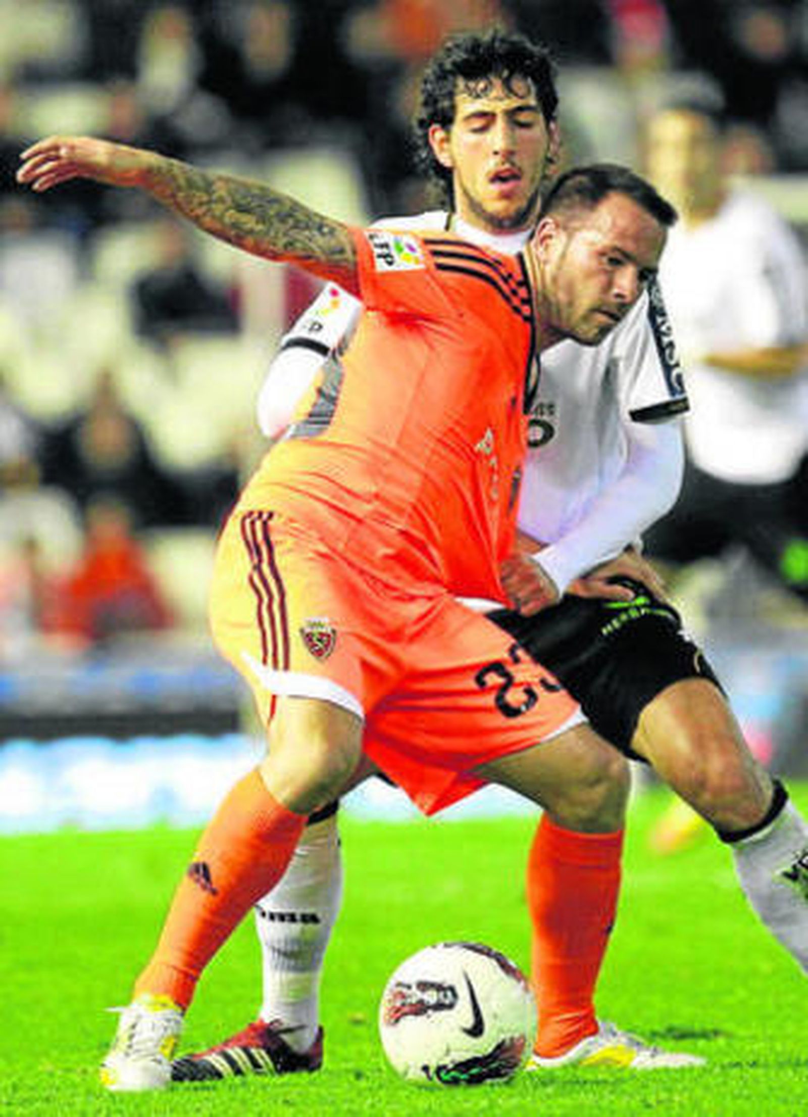 Apoño, autor de los dos goles maños, cubre el balón ante Parejo.