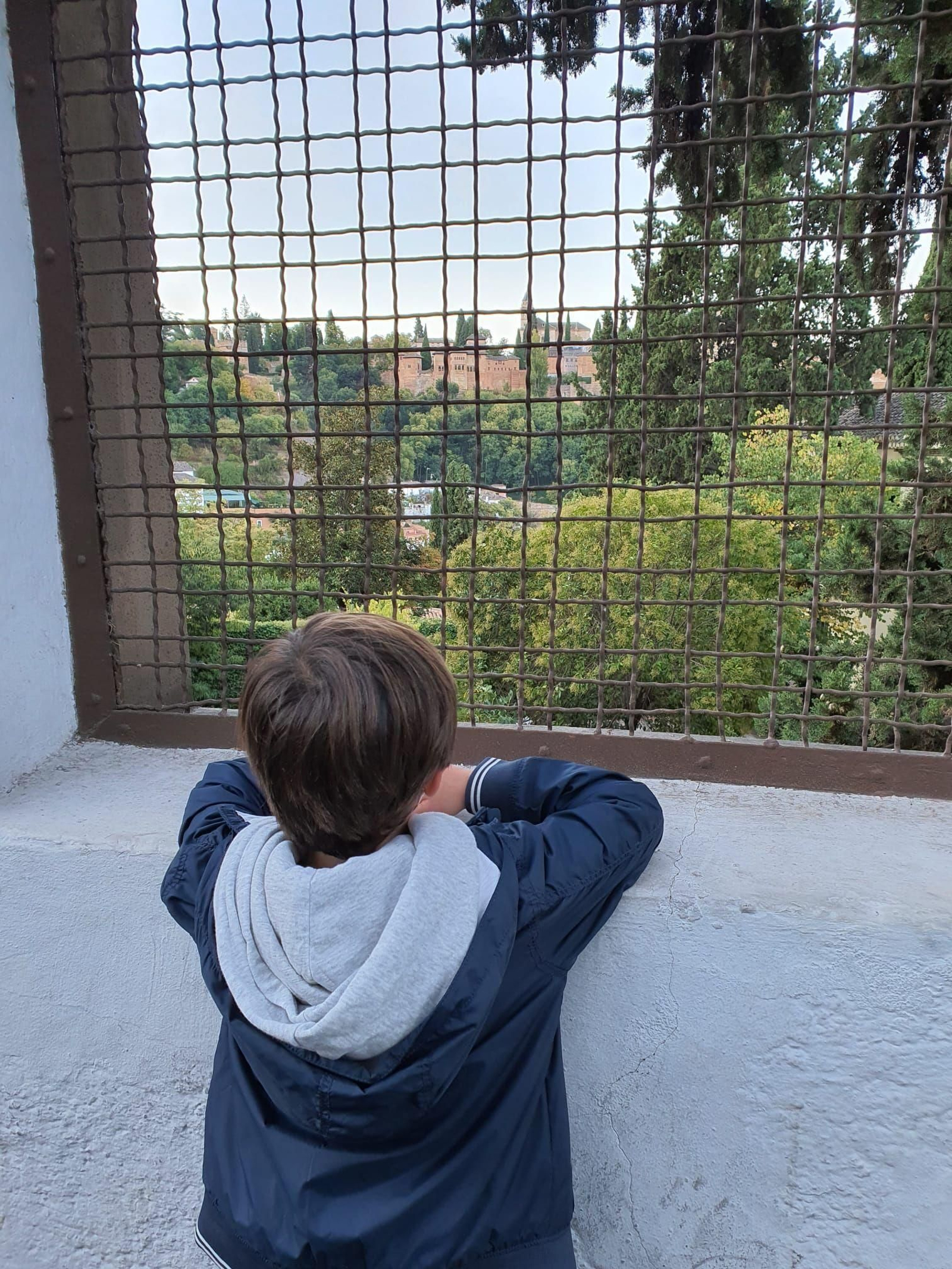 Un niño observa la Alhambra desde el Sacromonte.