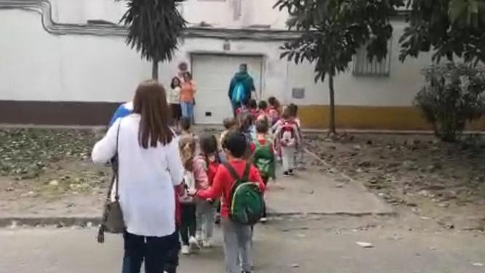 Alumnos, acompañados por madres y monitores, durante el traslado de un edificio a otro