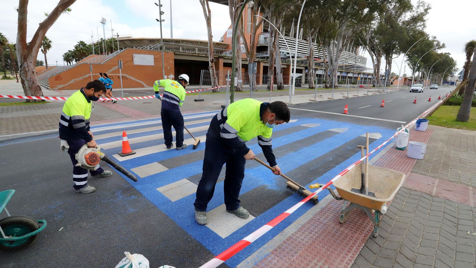 Imagen de los trabajos de pintado de los pasos de cebra con los colores del Recre.