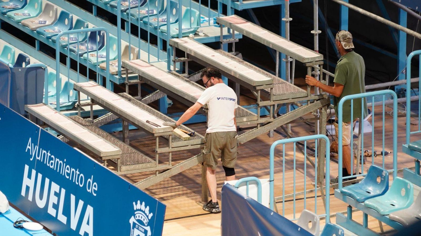 Operarios instalan una grada a pie de pista.