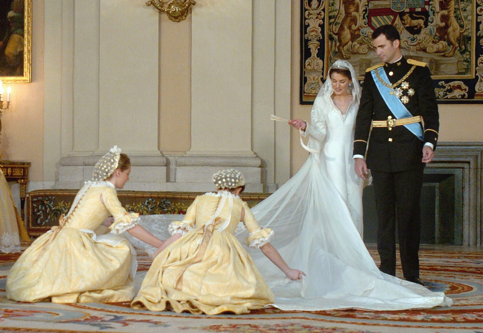 Las damas colocan la cola del vestido de la novia en el Palacio Real