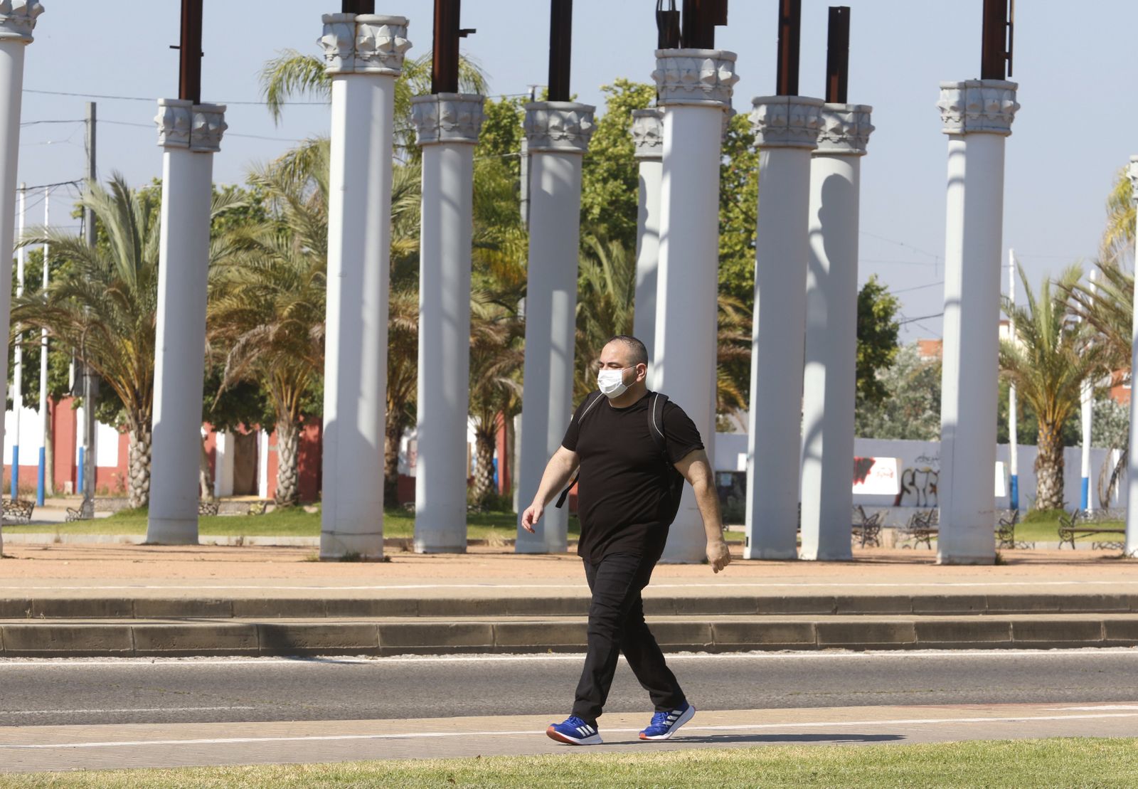 Un hombre pasea frente al esqueleto de la portada de la Feria.