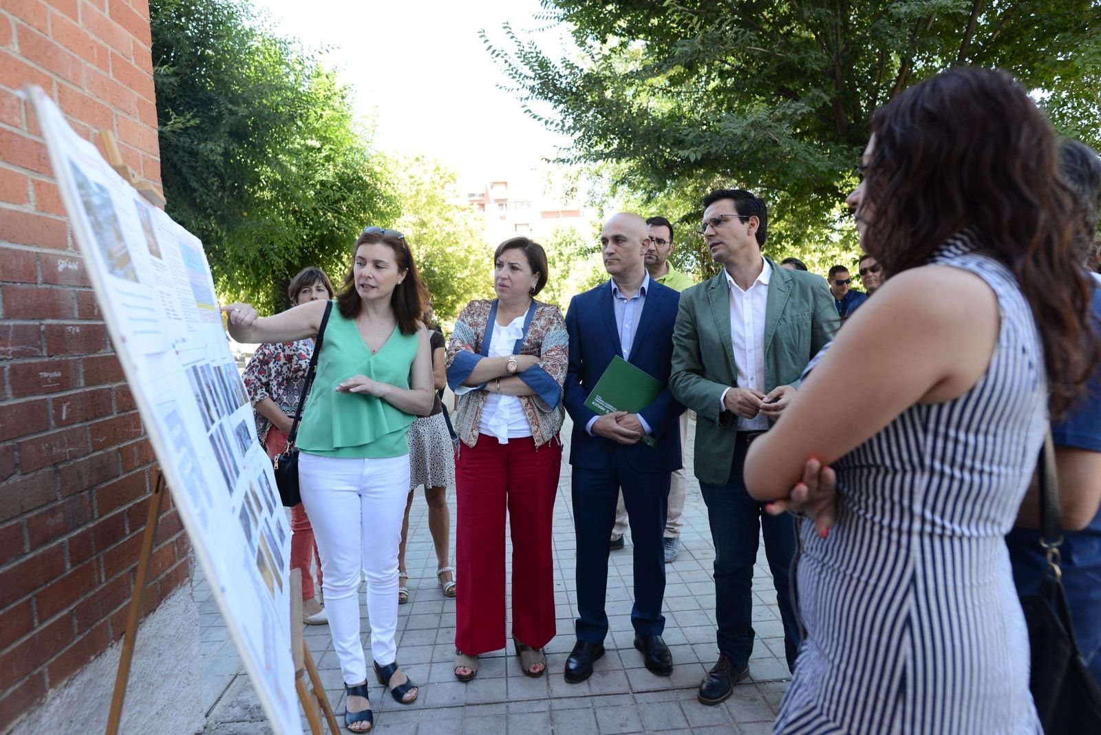 Los representantes de las instituciones consultan en un cartel informativo las actuaciones en las viviendas.