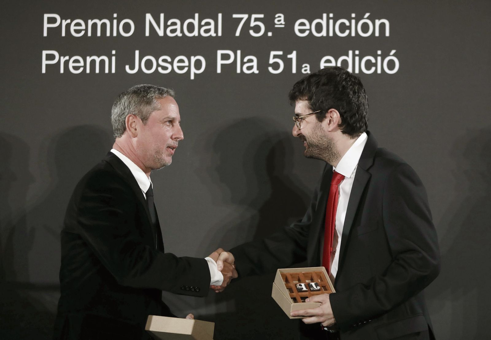 El ganador del premio Nadal, Guillermo Martínez (i), saluda a Marc Artigau, galardonado con el Premio Josep Pla, durante la gala.