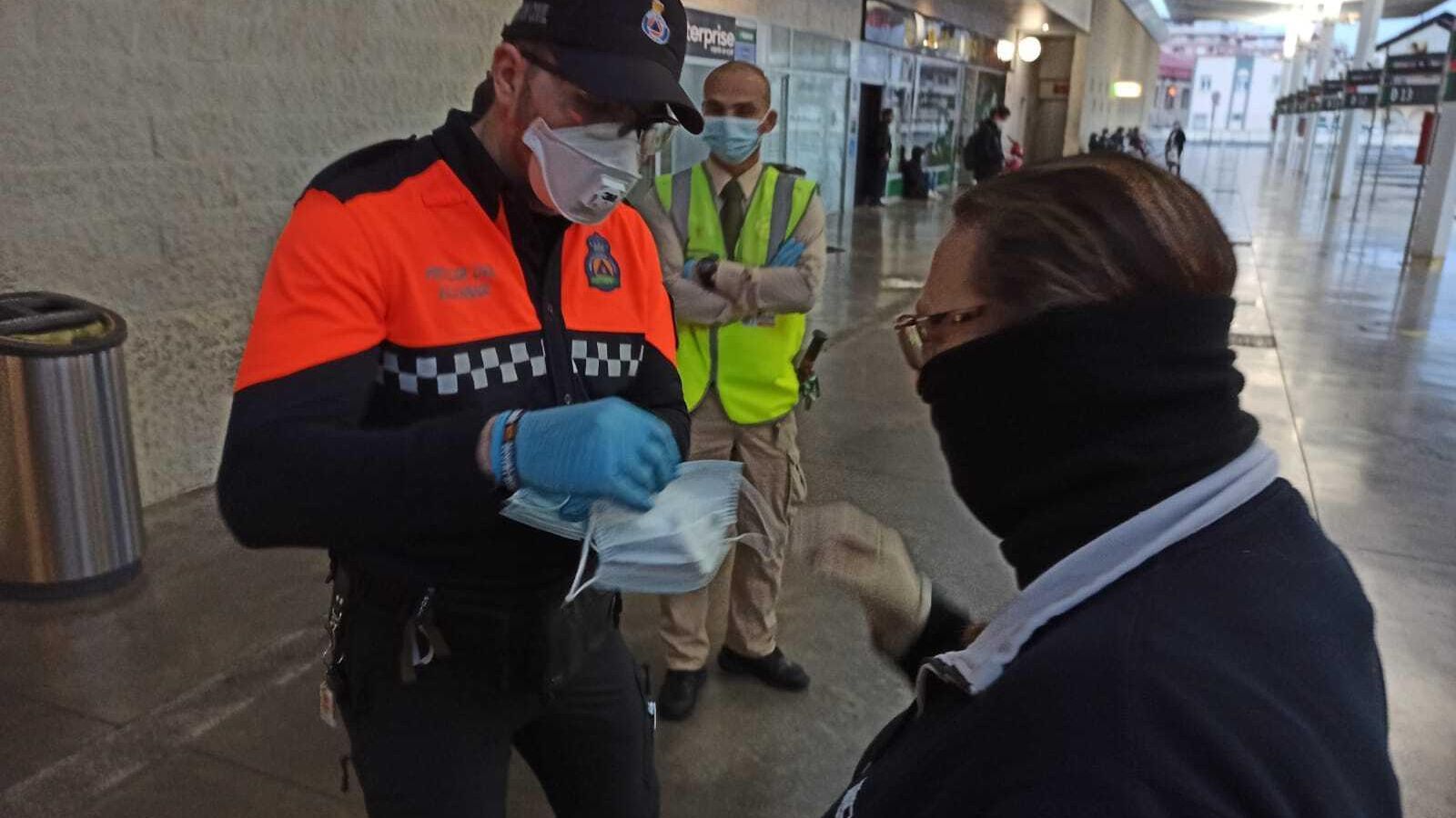 Miembro de Protección Civil repartiendo mascarillas en la Estación Intermodal de la capital.