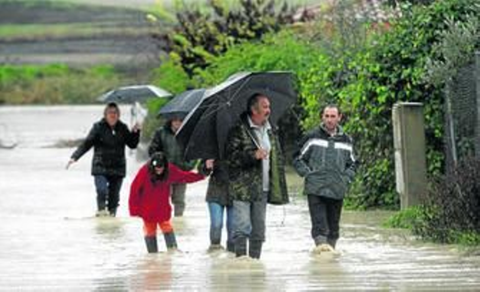 Una familia de la urbanización de Guadalvalle, en los aledaños del aeropuerto de Córdoba, tras desalojar su vivienda.