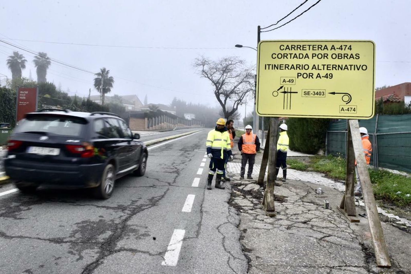 Operarios tras la colocación de la señalización que indica el corte de carretera.