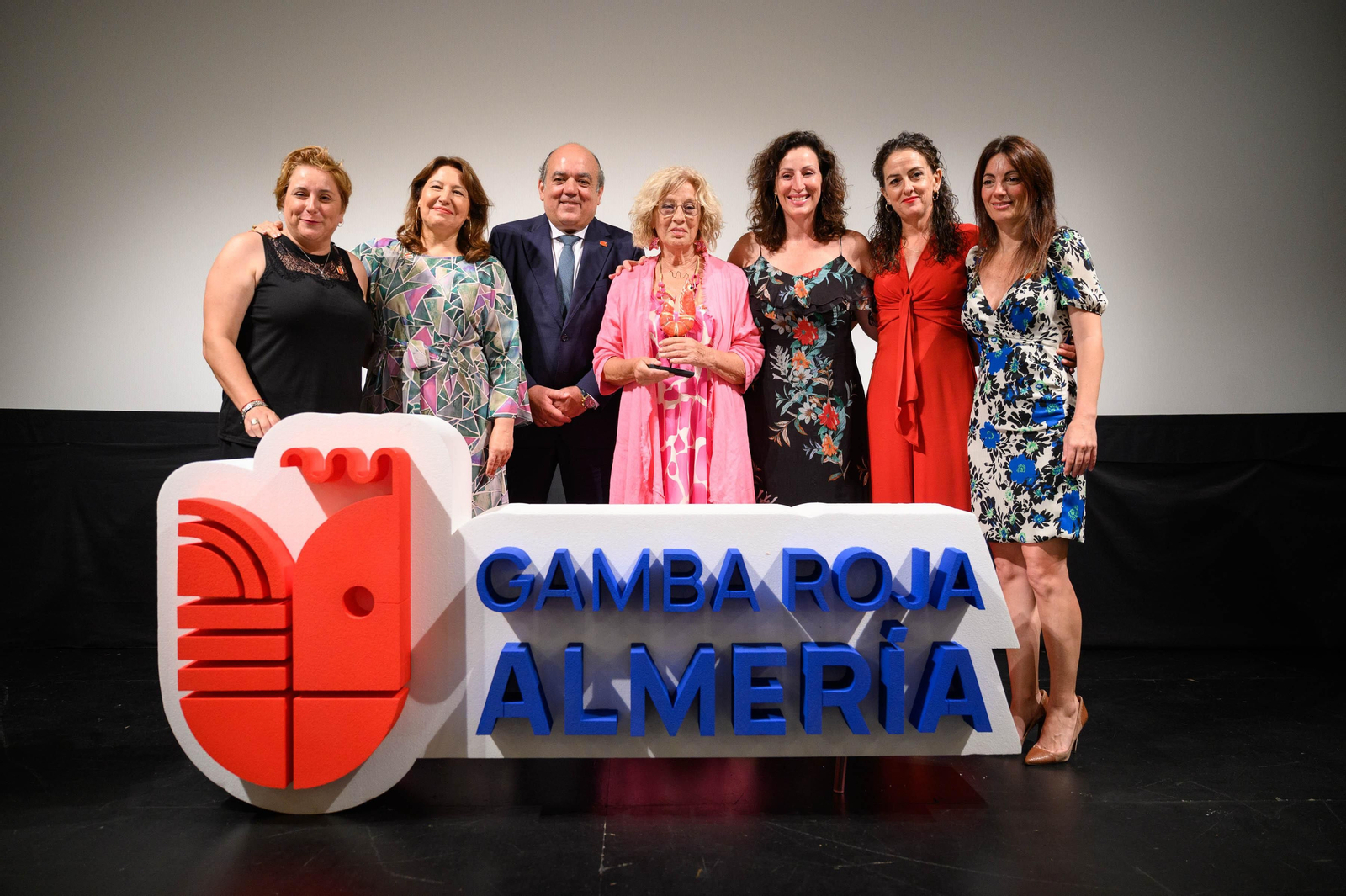 Foto de familia de las autoridades pesqueras y políticas, sobre el escenario del Apolo con la marca de la ‘Gamba Roja de Almería’.