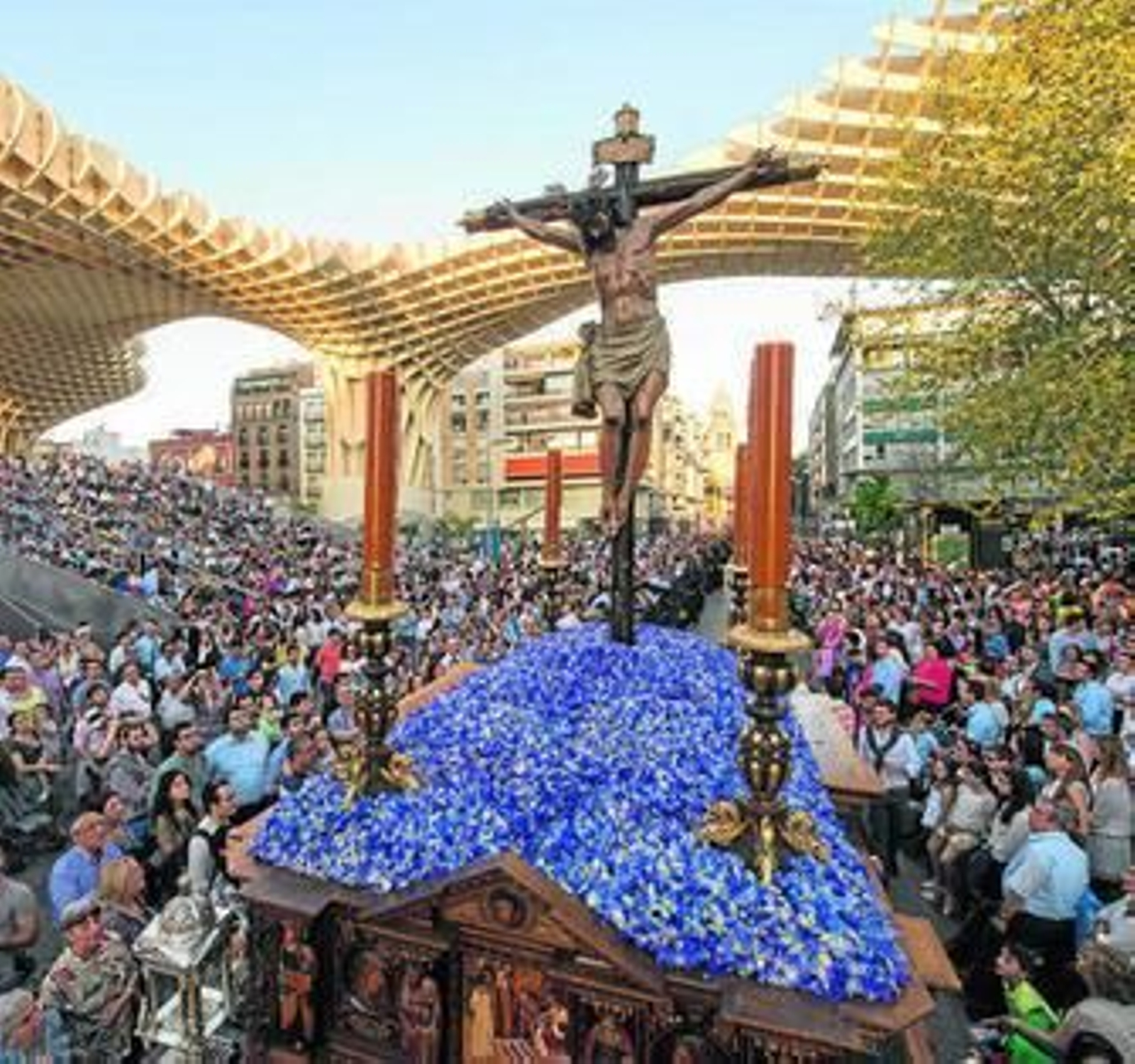 El Cristo de Burgos sevillano con el telón de fondo de las 'Setas' al pasar por la plaza de la Encarnación.