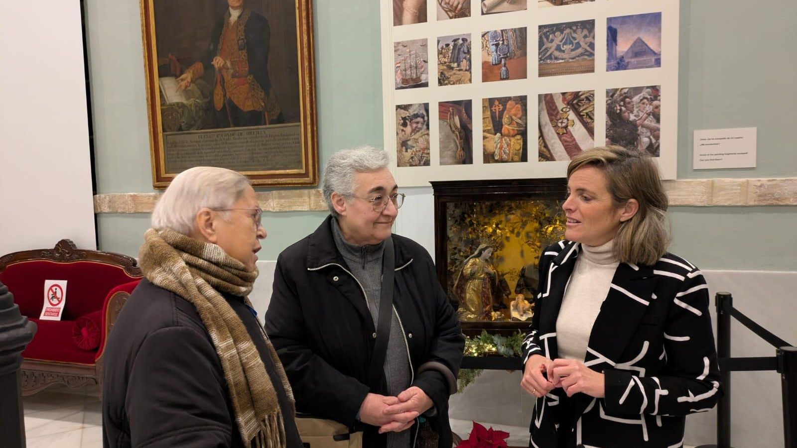 La edil de Cultura, Maite González, hablando con las monjas del Rebaño de María ante el nacimiento.