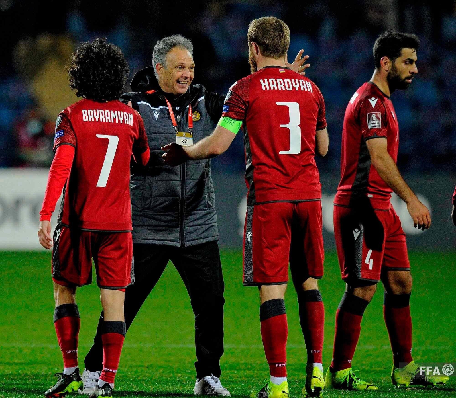 Joaquín Caparrós se abraza a dos de sus futbolistas tras un triunfo de Armenia.