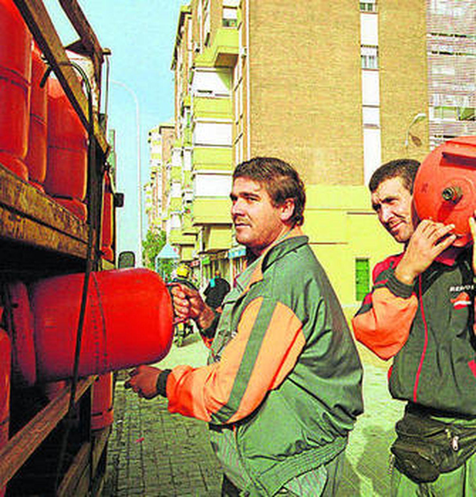 Dos repartidores de butano realizan su trabajo.