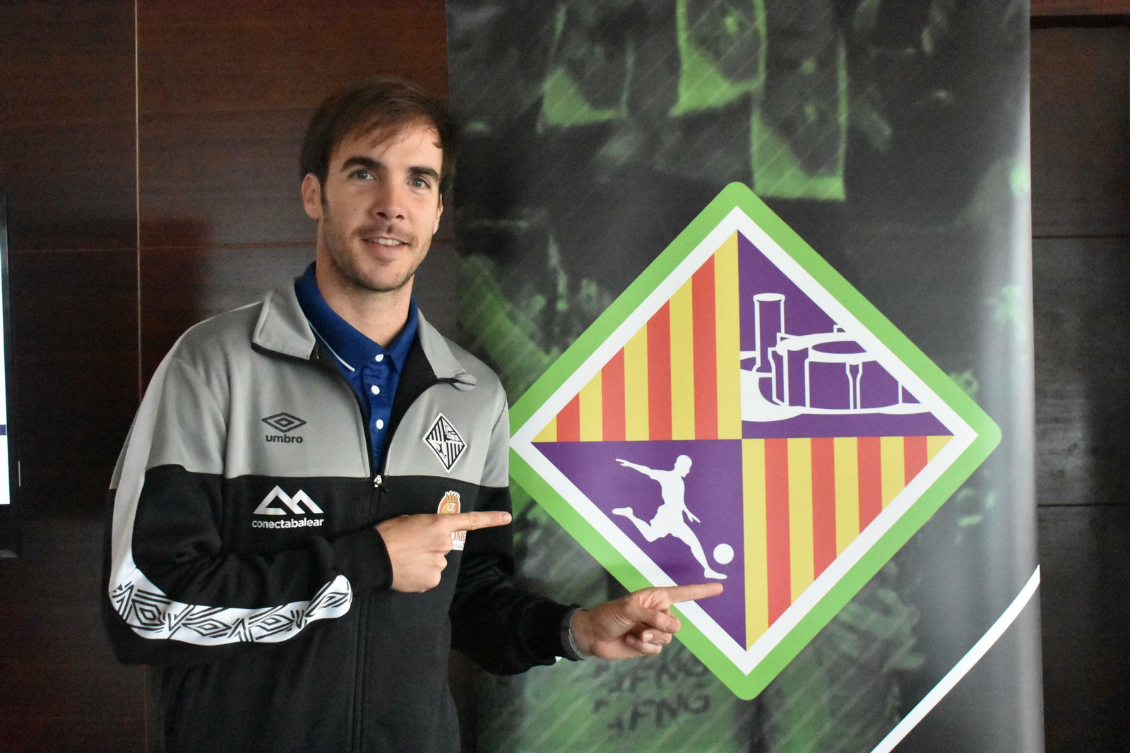 Carlos Barrón posa junto al escudo del Palma Futsal.